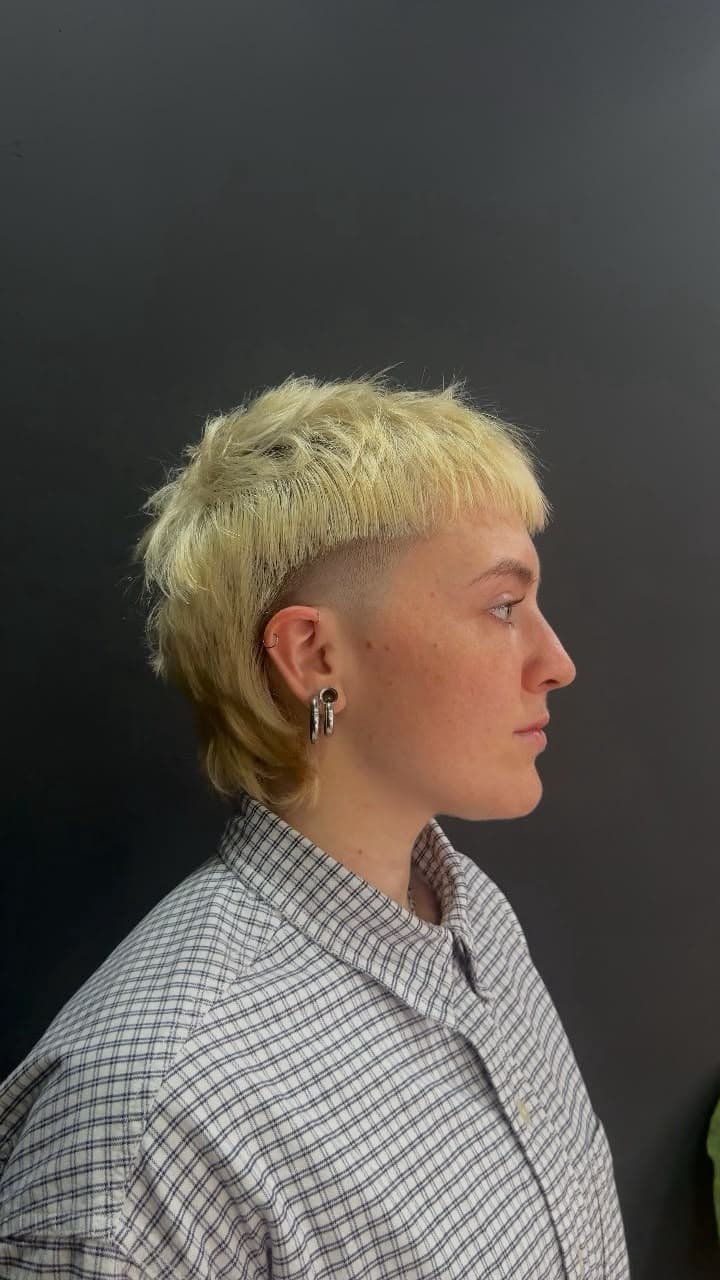 Platinum blonde mullet with a side fade, in profile